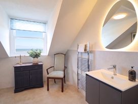 A bathroom with a sink and cabinet at Sea View, East Parade in Llandudno