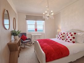 A bedroom with a bed and decorative pillows at Sea View, East Parade, Llandudno