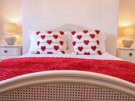 A bedroom with a bed and heart patterned pillows at Sea View, East Parade Llandudno
