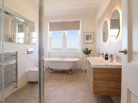 A bathroom with bathtub, sink, and towel radiator at Sea View, East Parade in Llandudno