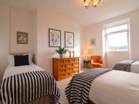 A bedroom with two beds and a dresser at Sea View, East Parade Llandudno