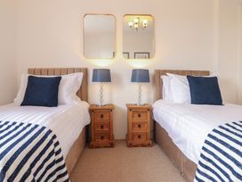 A bedroom with two beds and mirrors at Sea View, East Parade in Llandudno