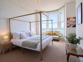 A bedroom with a four-poster bed and a sofa at Sea View, East Parade, Llandudno