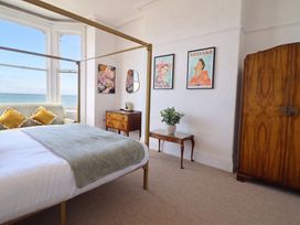 A bedroom with a bed and couch at Sea View, East Parade Llandudno