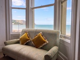 A living room with a sofa and cushions at Sea View, East Parade in Llandudno
