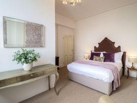 A bedroom with a bed and a mirror at Sea View, East Parade Llandudno