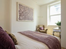 A bedroom with a bed and a chair at Sea View, East Parade in Llandudno