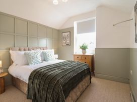 A bedroom with a bed and wooden furniture at Sea View, East Parade Llandudno