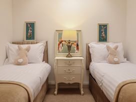 A bedroom with twin beds and a bedside table at Sea View, East Parade, Llandudno