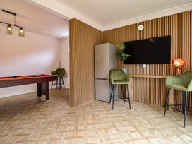 A game room with a pool table and refrigerator at Sea View, East Parade Llandudno