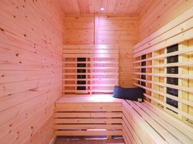 A sauna with wooden benches and a sauna heater at Sea View, East Parade, Llandudno