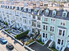 A row of houses with gardens and vehicles at Sea View, East Parade in Llandudno