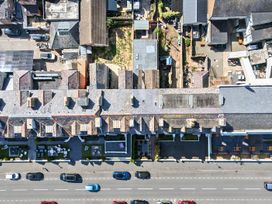 An outdoor area with rooftops, vehicles, and a garden at Sea View, East Parade in Llandudno