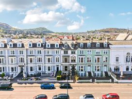 A row of houses with a road and cars at Sea View, East Parade Llandudno