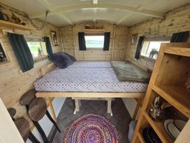 A bedroom with a bed and wooden decor at Restored circus wagon Saltburn-By-The-Sea
