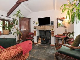 A living room with a fireplace and a television at Coach House in Camelford