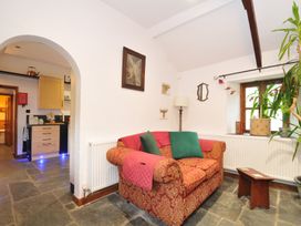 A living room with a sofa and lamp at Coach House, Camelford