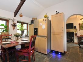 A kitchen with a dining table and refrigerator at Coach House, Camelford