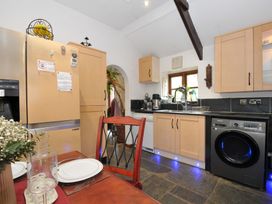 A kitchen with appliances and a table at Coach House in Camelford