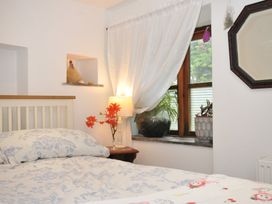 A bedroom with a bed and window at Coach House in Camelford