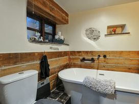 A bathroom with a bathtub and toilet at Coach House in Camelford