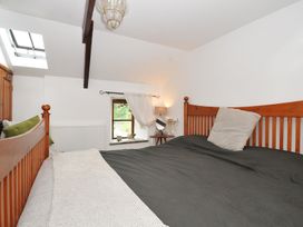 A bedroom with a bed and window at Coach House in Camelford