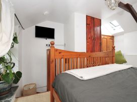 A bedroom with a bed and television at Coach House in Camelford
