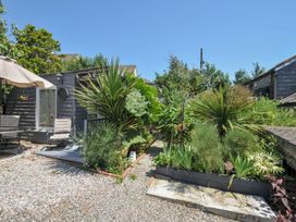 A garden with plant beds and outdoor seating at Coach House in Camelford