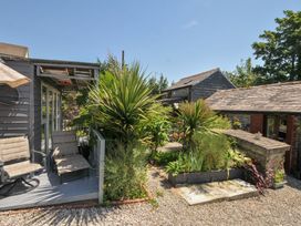 An outdoor area with a deck and plants at Coach House in Camelford