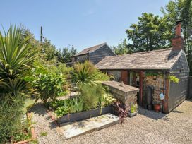 A garden with various plants and a stone structure at Coach House in Camelford