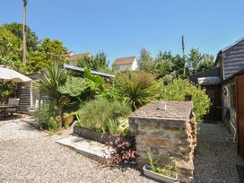 A garden with plants and a table at Coach House in Camelford