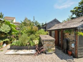 A garden with various plants and a building at Coach House in Camelford