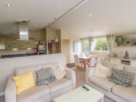 A living room with sofas and dining area at 56 The Stables