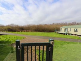A view of a pathway and cabin surrounded by grass at 56 The Stables
