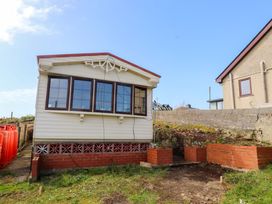 A caravan structure with windows outside at Caravan at Argraig Llanrhyddlad near Cemaes Bay