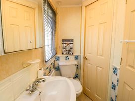 A bathroom with a toilet and washbasin at Caravan at Argraig Llanrhyddlad near Cemaes Bay