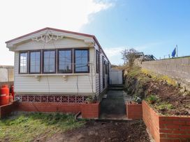 A caravan with a pathway and planter at Caravan at Argraig Llanrhyddlad near Cemaes Bay