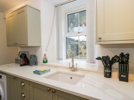A kitchen with a sink and kitchen cabinets at Bobtail Cottage in Kendal