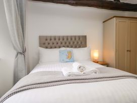 A bedroom with a bed and bedside lamp at Bobtail Cottage in Kendal