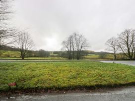 A field with trees and a road at Bobtail Cottage in Kendal