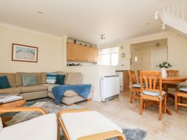A living room with a sofa and dining area at Oak Cottage in Falmouth