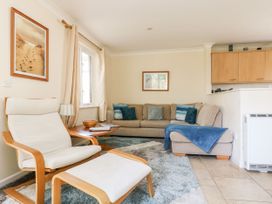 A living room with a sofa and armchair at Oak Cottage in Falmouth