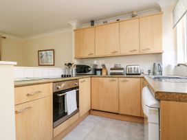 A kitchen with appliances and cabinets at Oak Cottage in Falmouth