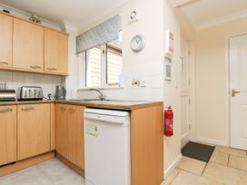 A kitchen with cabinets and appliances at Oak Cottage in Falmouth