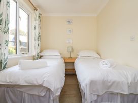 A bedroom with two single beds and a lamp at Oak Cottage in Falmouth