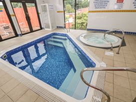 An indoor pool area with a swimming pool and spa pool at Oak Cottage Falmouth