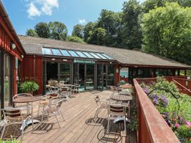 An outdoor seating area with chairs and a bar entrance at Oak Cottage in Falmouth