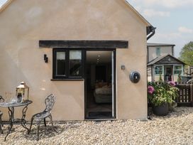 An outdoor area with a table and chairs at Ruby’s Den Ashton Keynes