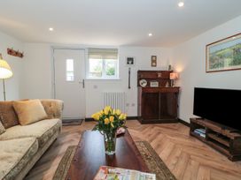 A living room with a sofa, coffee table and tv at Ruby’s Den Ashton Keynes