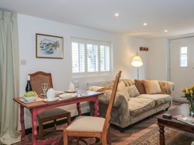 A living room with a sofa and dining table at Ruby’s Den Ashton Keynes